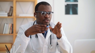 医生在远程保健电话与病人交谈。Spbas非洲男性在视频聊天讲解医疗咨询视频素材模板下载