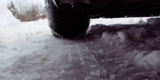 特写轮胎与雪链驾驶在雪和结冰的道路