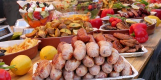 一桌丰盛的香肠，烤蔬菜，红辣椒，西葫芦，茄子，土豆。街头美食节，高脂肪食品，快餐