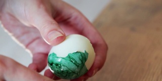 清洗一个彩色的煮鸡蛋。复活节的象征