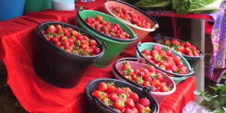 农贸市场上满桶的草莓。成熟的红色有机草莓
