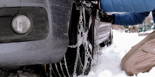 汽车被困在雪中，人们无法在轮胎上安装防雪链