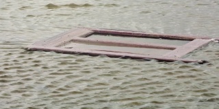 破损的门漂浮在水面上，这是阿根廷的一个鬼城，4K分辨率。
