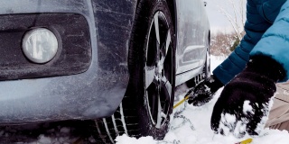 父亲和儿子被困在雪中，无法在轮胎上安装防雪链