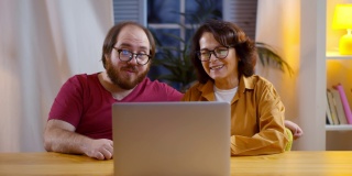 成年的儿子和年老的母亲正在用笔记本电脑和家人视频通话
