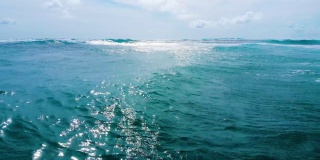 海滩上的流浪汉，近距离拍摄的白色泡沫的海浪在印度尼西亚的巴厘岛