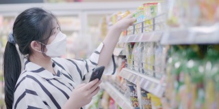 亚洲妇女在超市使用电话