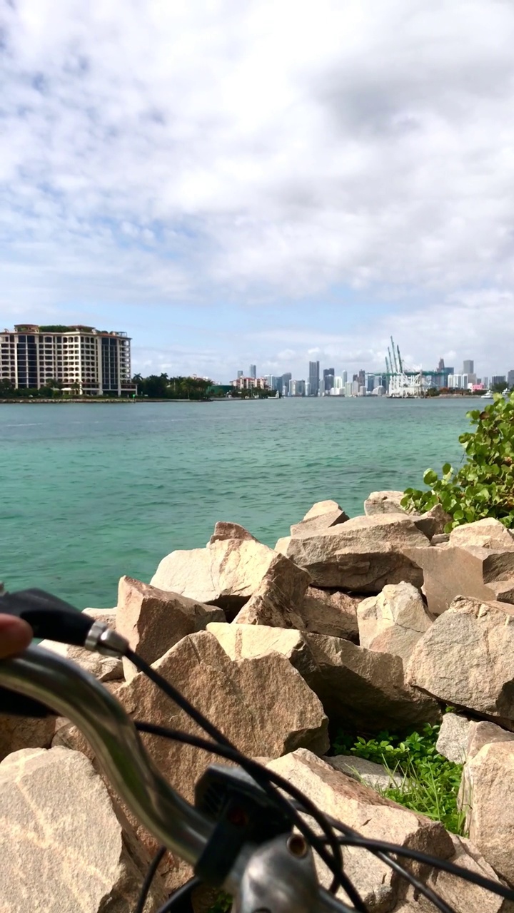 视角拍摄的一个年轻的运动男子骑自行车在南海滩，迈阿密海滩，迈阿密，南佛罗里达，美利坚合众国的南角公园