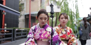 穿着和服的年轻女性朋友为了拍视频而吃街头小吃