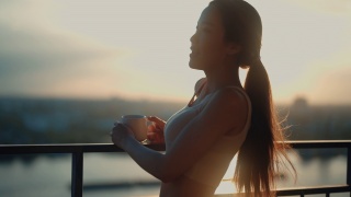 健康的女人享受日落带来的和平。视频素材模板下载