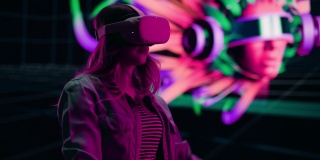 数字艺术家制作一个现代VR软件制作3D艺术作品的演示。女设计师使用耳机和控制器在舞台上的大屏幕上展示功能。