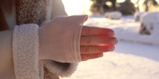 特写镜头冻结不认识的女人塞冻僵的手在夹克口袋站在寒冷的冬天的户外。