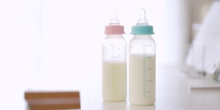 亚洲父母正在给双胞胎婴儿喂奶