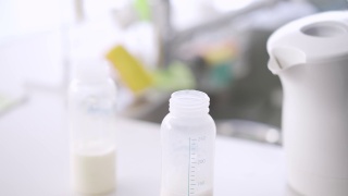 亚洲男人为双胞胎婴儿制作牛奶视频素材模板下载