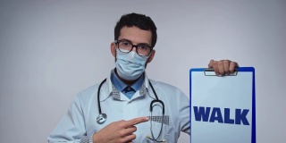身穿白大褂、听诊器的医生展示了带处方单和WALK字样的纸架。医生建议