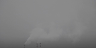 在一个灰蒙蒙的多雾的冬日里，锅炉房的烟囱里升起了烟