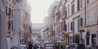 一条繁忙狭窄的街道，有许多汽车可以俯瞰竞技场。意大利罗马