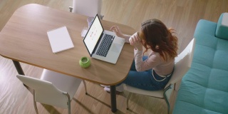 女性专业用户使用PC技术在家庭办公室做在线工作