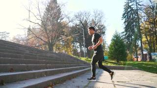年轻的亚洲男子运动员运动员脚跑上楼梯训练激烈的有氧运动锻炼男性跑步者的腿在台阶上慢跑在城市背景。视频素材模板下载