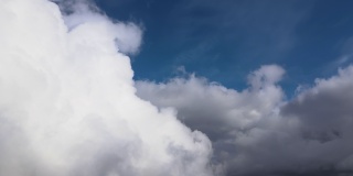 从飞机窗口高空俯瞰，在暴雨前形成的蓬松的积云覆盖着大地