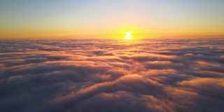 从高空俯瞰，浓密蓬松的积云在傍晚飞舞。从飞机窗口看到的令人惊叹的日落