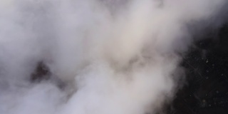 高空鸟瞰图，远处的城市被暴雨前形成的蓬松的积云所覆盖。飞机角度多云的景观