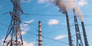 高压电塔与燃煤发电厂的高管道黑烟向上移动污染大气。以化石燃料的概念生产电能