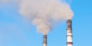 火力发电厂的高管与黑烟向上移动污染大气的特写。以化石燃料的概念生产电能