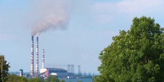 燃煤电厂的高管道，黑烟向上移动污染大气。以化石燃料的概念生产电能