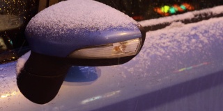 汽车在冬天的道路上。后视镜的特写镜头。闪光报警。
