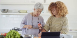 活跃的老年妇女和孙女一起做健康的饭菜