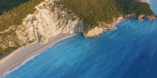 从高空俯瞰希腊爱奥尼亚岛莱夫卡达美丽的米洛斯海滩。夕阳金色的阳光，碧蓝的大海，原始的海浪在岸边翻滚
