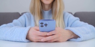 打字信息在线社交媒体应用程序在现代蓝色手机与三摄像头。快乐的白人女性使用新的智能手机设备进行交流，4k库存镜头