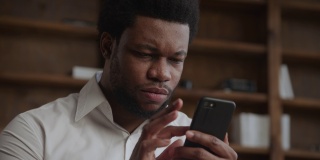 一名年轻的非洲裔美国人在智能手机上浏览内容时表现出了负面反应