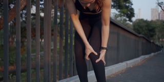 运动妇女在公园户外慢跑运动时膝盖疼痛，身体状况疼痛关节韧带问题。