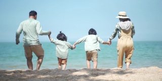 4K幸福家庭牵着手，在夏天的一天跑到海边