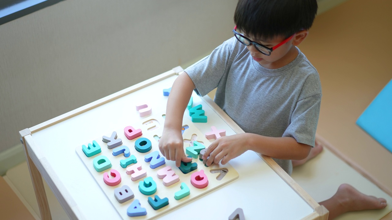 亚洲男孩学习英语字母，玩具和字母表。重返校园的概念