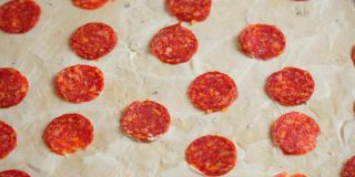 用香肠和蘑菇做披萨的特写。比萨配料。