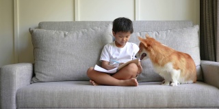 亚洲孩子和狗狗一起在线学习。新常态研究与检疫的概念