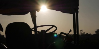 夕阳下拖拉机站在稻田里的剪影。有机农业。农业和农业综合企业
