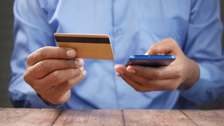 手持信用卡和智能手机在线购物视频素材模板下载