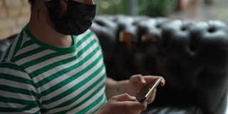 一个中年男子戴着口罩玩手机