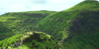 印度古吉拉特邦萨普特拉的总督山的广角镜头。萨哈德里山脉的绿色丘陵在季风季节。人们在假期期间在萨普塔拉的绿色山丘上徒步旅行。