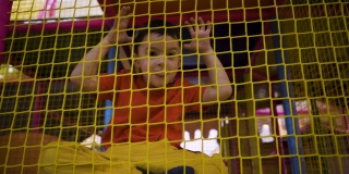 一个五岁的小男孩在一个游乐园的摄像机前扭动着