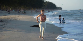 健康的生活方式年轻女子在海滩上跑步