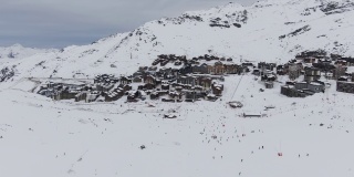 雪山滑雪场。令人惊叹的无人机视图小镇和滑雪场位于雪山山脊附近的冬季