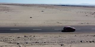 汽车穿越沙漠，无人机视图，汽车在阿塔卡马沙漠驾驶的无人机镜头，世界上最干燥的非极地沙漠，智利，南美。