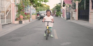一个亚洲小女孩喜欢在街上骑儿童自行车