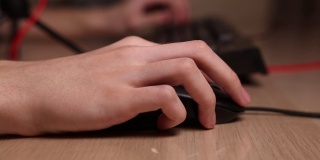 男性手用电脑鼠标键盘工作的特写镜头