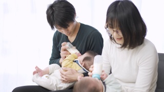 亚洲父母正在给双胞胎婴儿喂奶视频素材模板下载